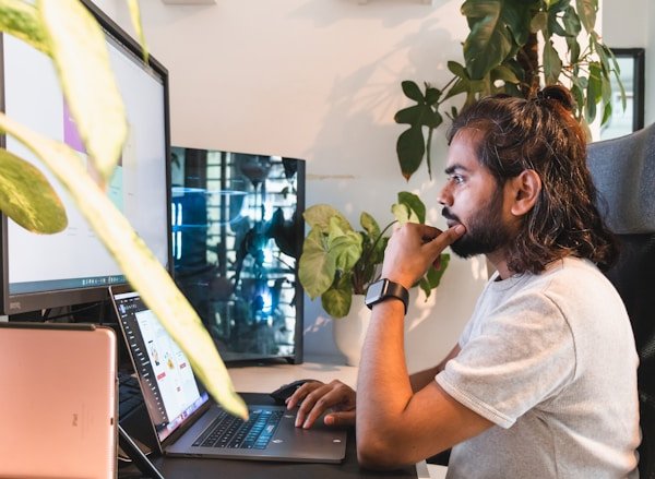 A programmer reviewing AI-suggested code changes on a laptop at a desk