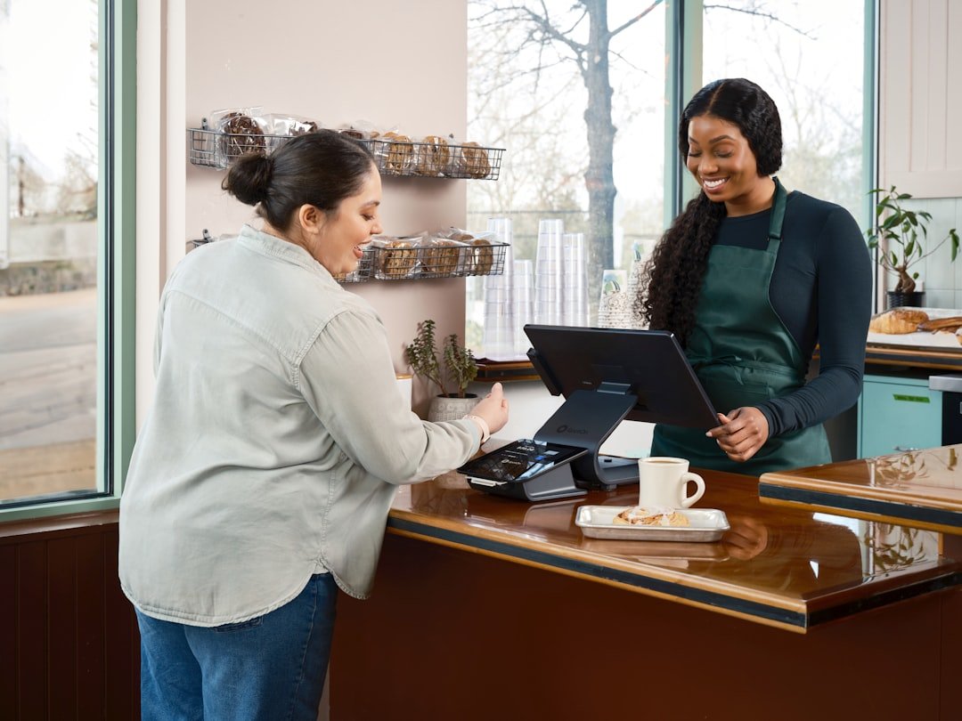 a small business owner using free AI tools for small business tasks at the counter, warm natural lighting