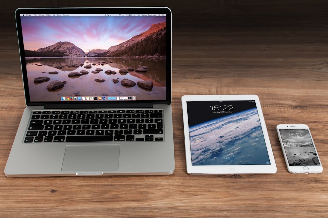 a laptop and notebook on a desk while reviewing files