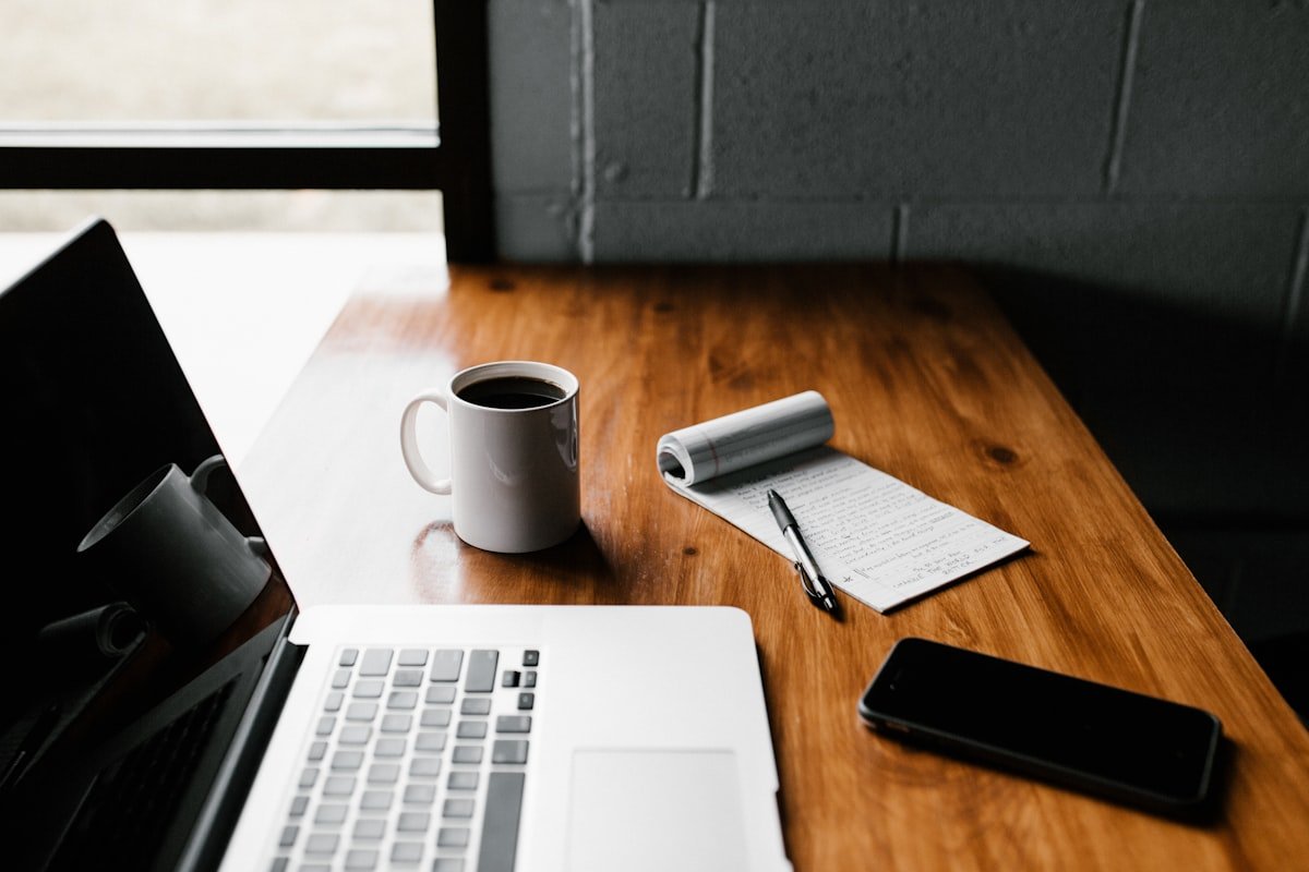 laptop and notepad set up for writing a free ai resume builder draft