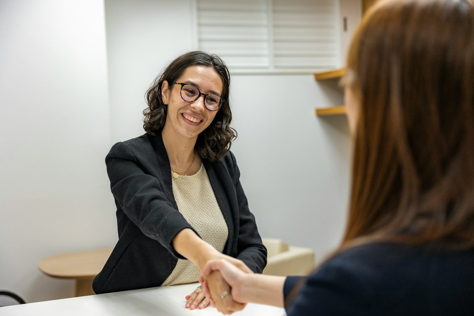 Job applicant shaking hands with a hiring manager after a successful interview