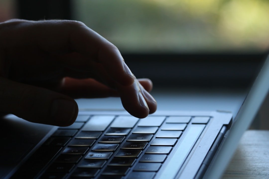 hands typing a master password on a laptop keyboard