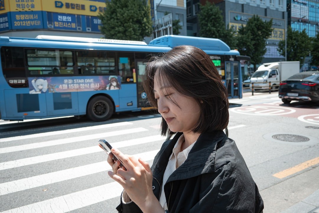 a woman checking her phone on a Seoul street, where Korean AI apps compete with ChatGPT