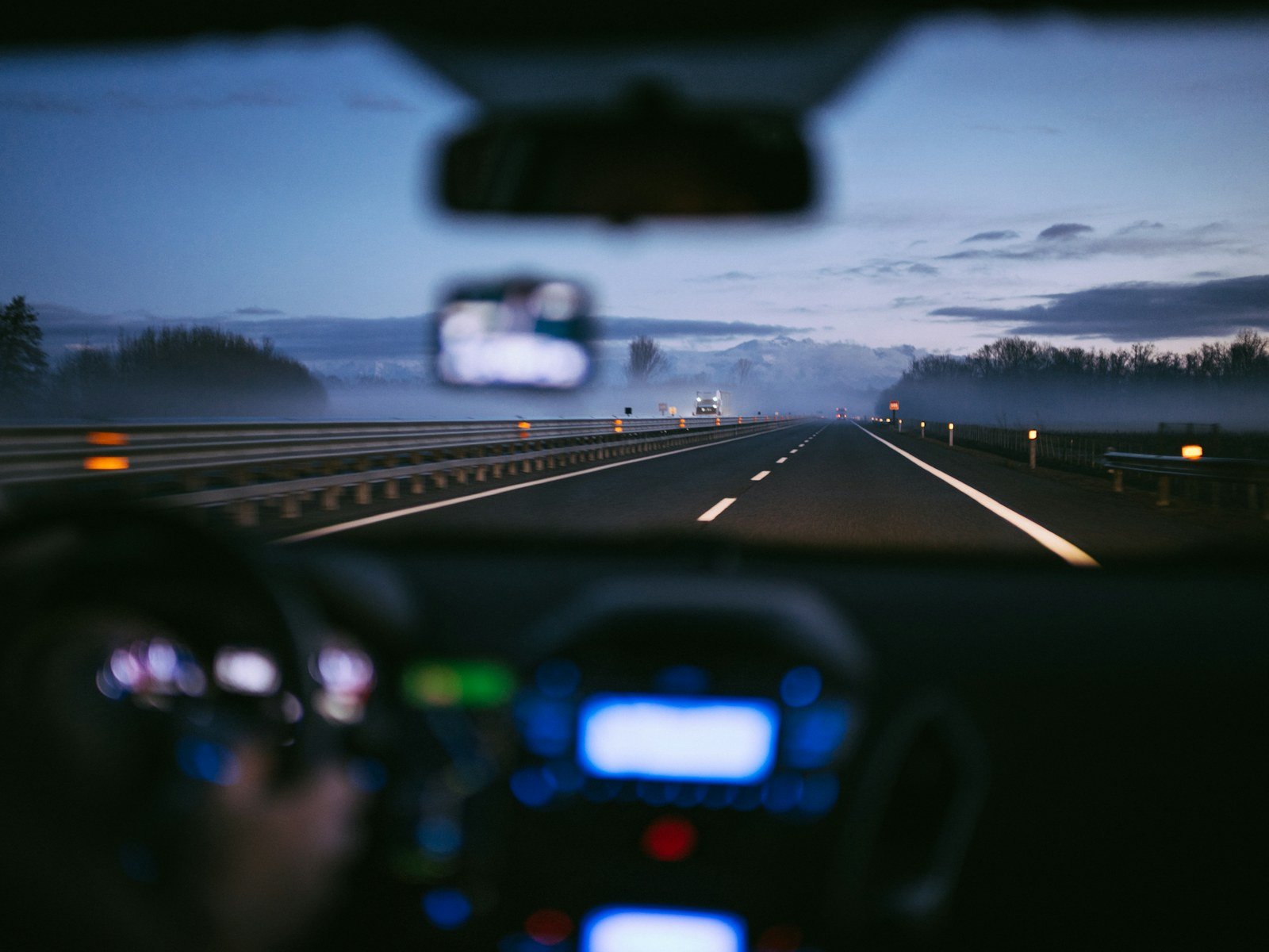 the view from inside a car driving on a highway at dusk