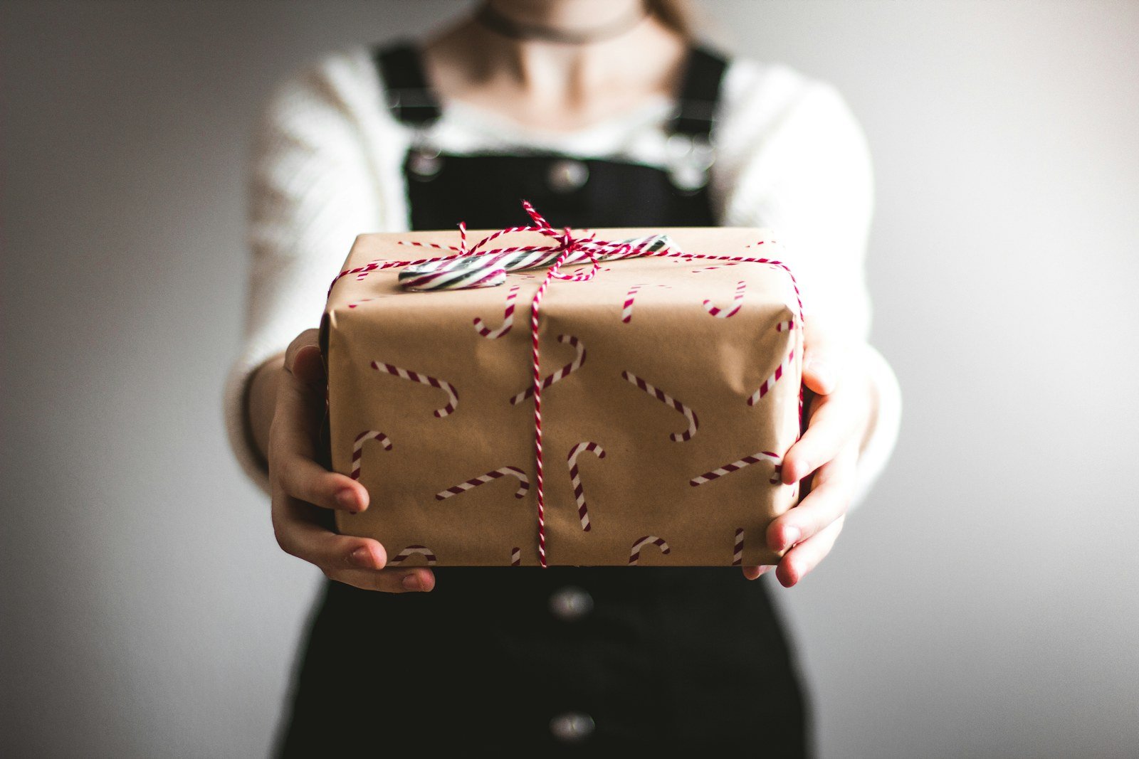 a person holding out a wrapped gift box
