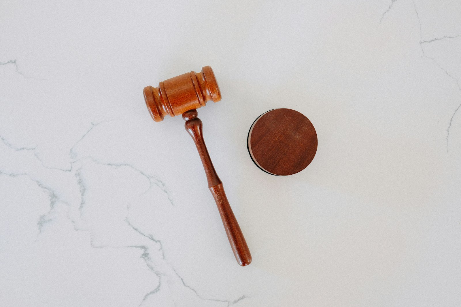 a wooden gavel and block resting on a marble surface