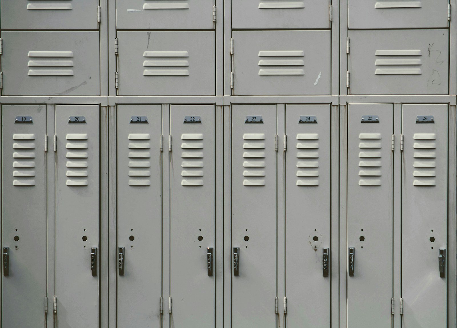 a row of grey school lockers in an empty corridor
