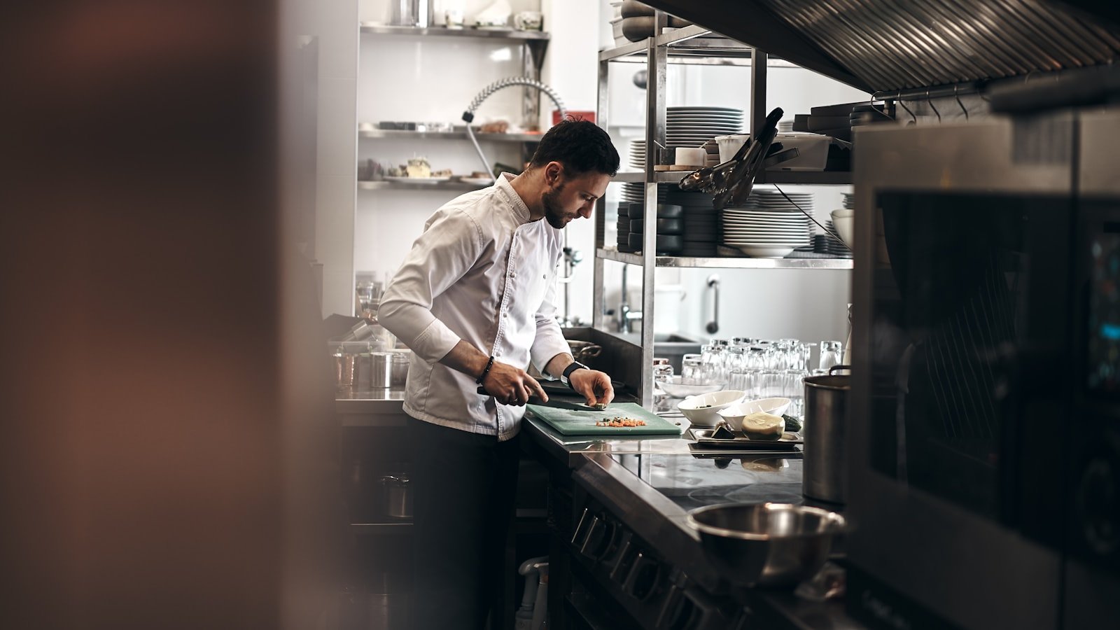 a chef chopping vegetables in a small restaurant kitchen