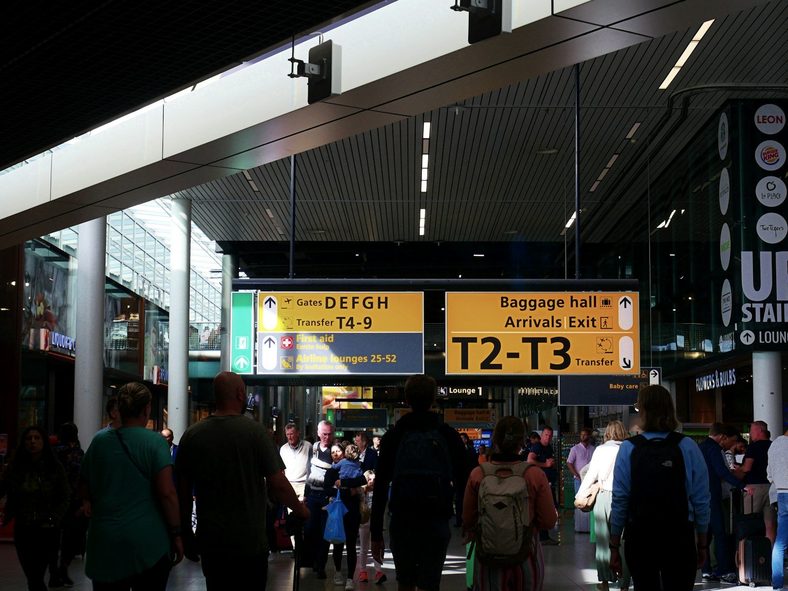 travellers walking through an airport terminal towards arrivals