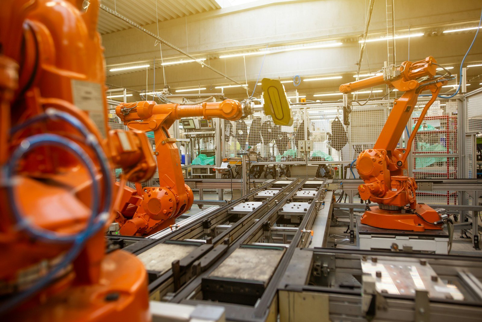orange industrial robots working along an automated assembly line