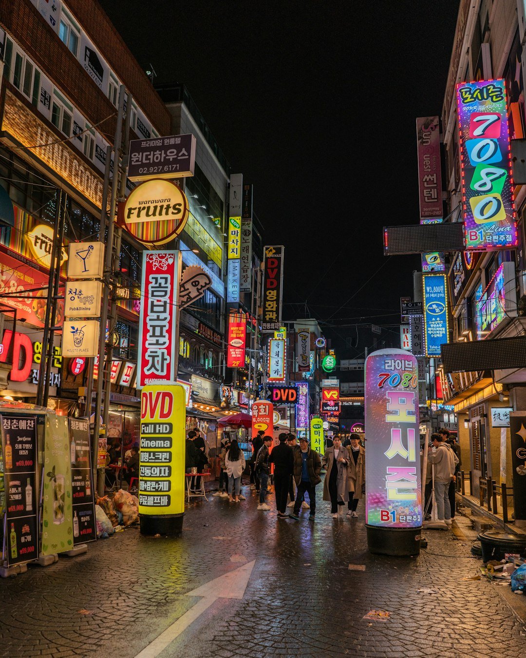 a busy Seoul nightlife street with dense Korean signage