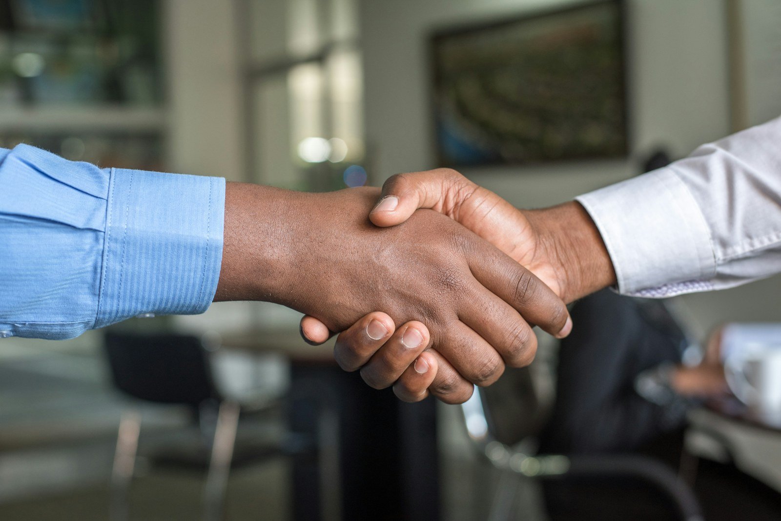 two people shaking hands at the end of a job interview