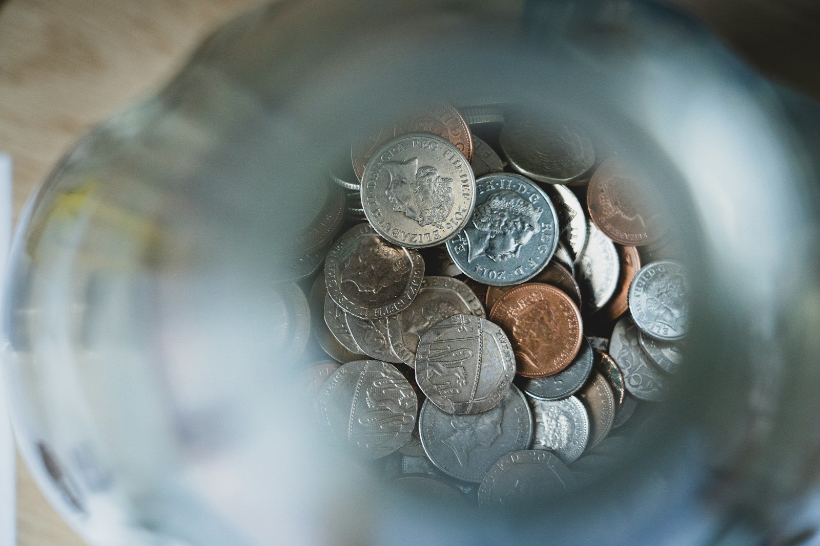 coins collected in a glass savings jar
